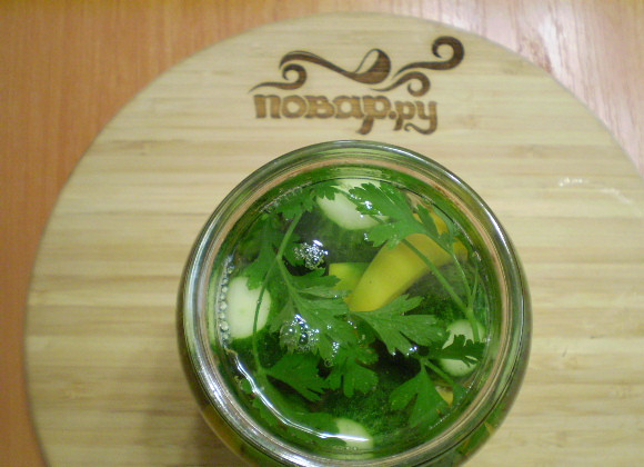 1. Этап. Ядреные огурчики: Укладываем огурчики, между ними — перец горький целиком, перец болгарский, корешки, чеснок. Заливаем кипятком, стерилизуем банку 5 минут. Вливаем уксус, и закатываем. Переворачиваем вверх дном и оставляем остывать. Потом убираем в прохладное место для хранения.