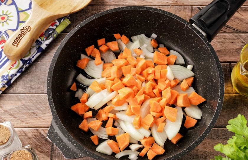 1. Этап. Печеночный паштет из свиной печени: Очистите лук и морковь от кожуры, сразу же промывая в воде после чистки. Нарежьте лук полукольцами, морковь можно нарезать произвольно. Выложите овощи на разогретую сковороду с маслом.