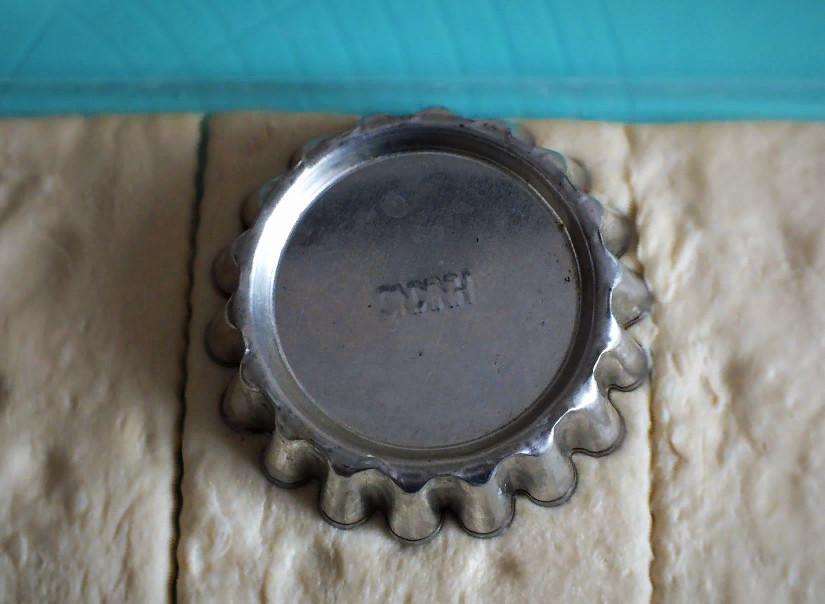 1. Этап. Корзиночки со взбитыми сливками: Подготовьте рабочую поверхность. Если ваше тесто рулоном, раскатайте рулон и оставьте его на слюде. Если тесто пластами, слегка сделайте несколько прокатов в одном направлении, сильно не раскатывайте. Возьмите формочку для корзиночки и слегка придавите. Тесто разрежьте на квадраты.