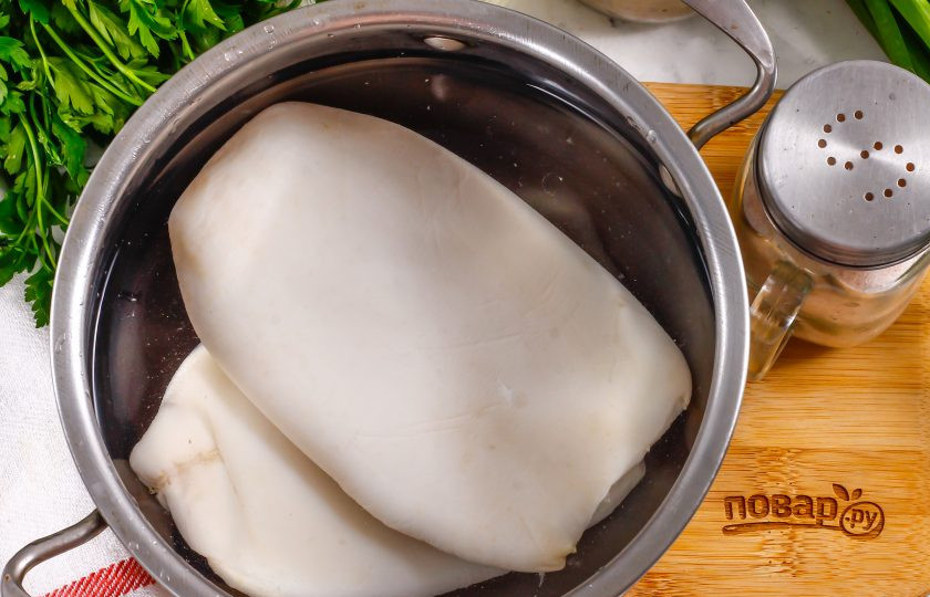 1. Этап. Блинчики с кальмарами: В кастрюле вскипятите воду, очистите кальмары и выложите их в кипяток на 2 минуты, отваривая до готовности. Затем извлеките и остудите.