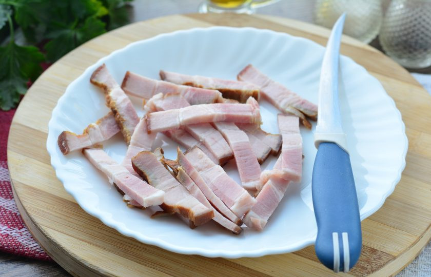 1. Этап. Салат с квашеной капустой и жареным беконом: Нарежьте бекон средними полосками.