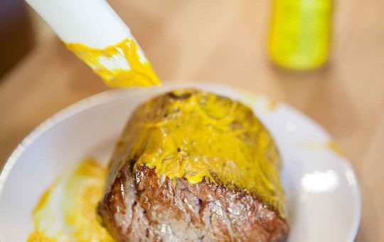 1. Этап. Говядина в горчице и слоеном тесте: 2. Смажьте со всех сторон горчицей сразу после обжарки (пока мясо горячее). После этого его можно посолить и приправить по вкусу. На масле, на котором жарилось мясо, обжарьте грибы, после чего измельчите их блендером до состояния паштета.