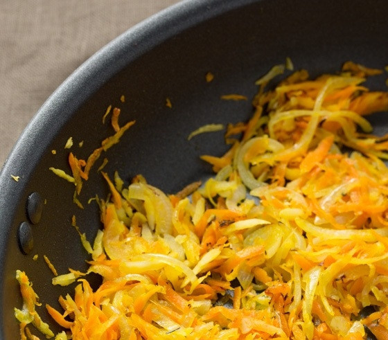 1. Этап. Настоящий украинский борщ: 4. Разогрейте сковороду с растительным маслом, выложите лук, обжаривайте пару минут и добавьте морковь, корень петрушки, готовьте еще 5 минут, переложите содержимое в тарелку.