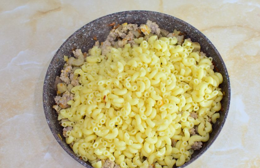 1. Этап. Макароны с фаршем и белыми грибами: Затем выложите макароны. Прогрейте все вместе 1-2 минуты и снимите сковороду с огня.