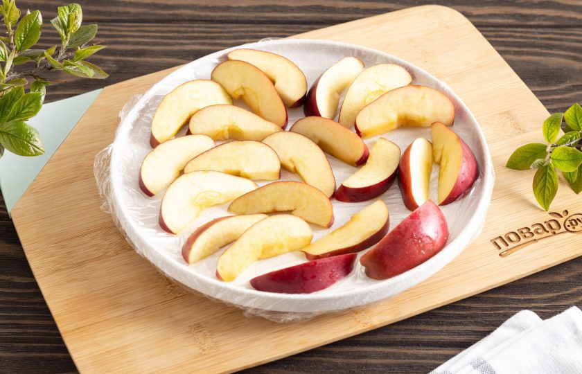 1. Этап. Как заморозить яблоки на зиму: Выложите яблоки в один слой на застеленную пищевой пленкой доску или большую тарелку. Уберите в морозильную камеру на 30-40 минут.