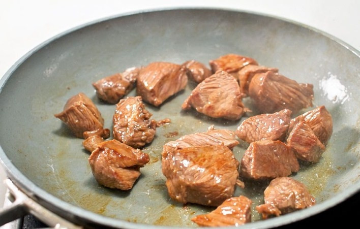 1. Этап. Телятина в горшочках: Мясо обжарьте на сковороде на среднем огне со всех сторон, посолите и поперчите по вкусу.