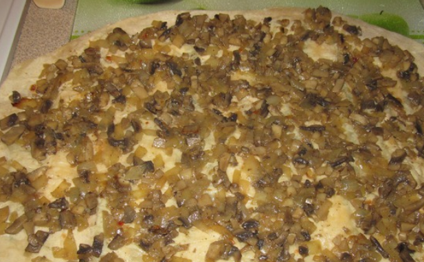 1. Этап. Запеченный лаваш: Измельчите лук и грибы, обжарьте их вместе на растительном масле до готовности. Затем выложите поверх лаваша.