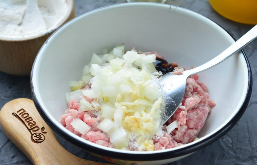 1. Этап. Котлеты по-корейски: Добавьте мелко нарезанный лук и чеснок. Перемешайте фарш для котлет.