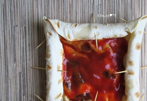 1. Этап. Яичница в лаваше Эти глаза напротив: Заверните сыр в лаваш с каждой стороны так, чтобы в центре получился квадрат, размером примерно с ломтик плавленого сыра. Закрепите зубочистками (мой домашний лаваш был не слишком мягкий и все норовил развернуться, поэтому я использовала зубочистки и для закрепления углов). Смажьте середину лаваша 1 ст. л. томатного соуса.