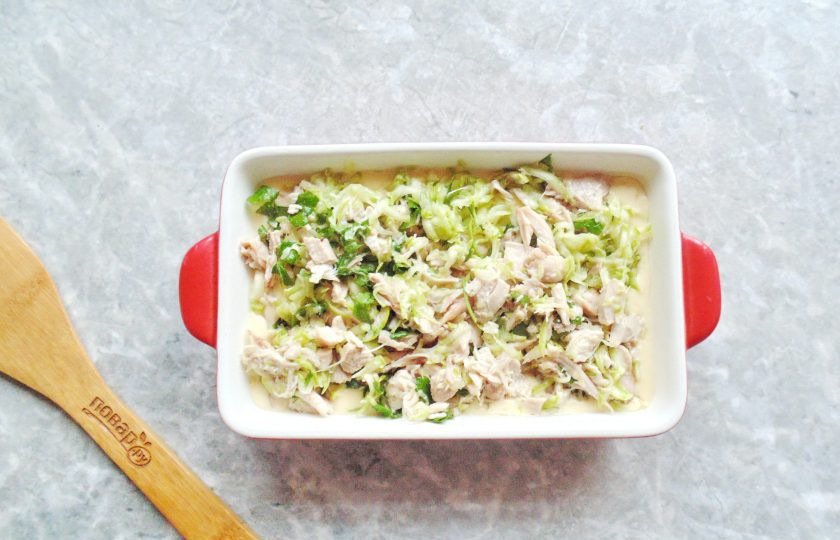 1. Этап. Заливной пирог с курицей и кабачком: В форму для запекания вылейте половину теста. Сверху выложите начинку.