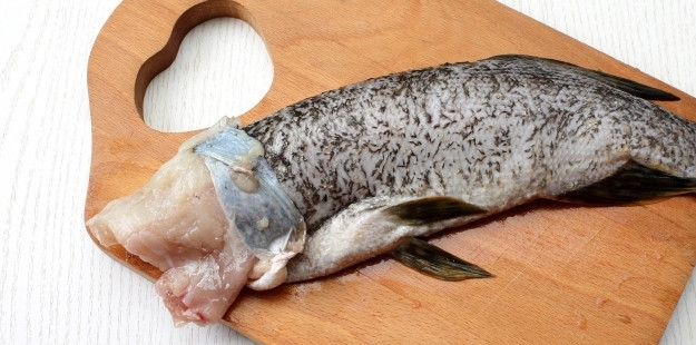 1. Этап. Рыба по-уральски: Теперь вам необходимо снять кожу так, чтобы она не порвалась. Аккуратно стягивайте ее от головы к хвосту, подрезая мякоть ножом. В районе хвоста разрубите хребет, чтобы сам хвост остался на коже.