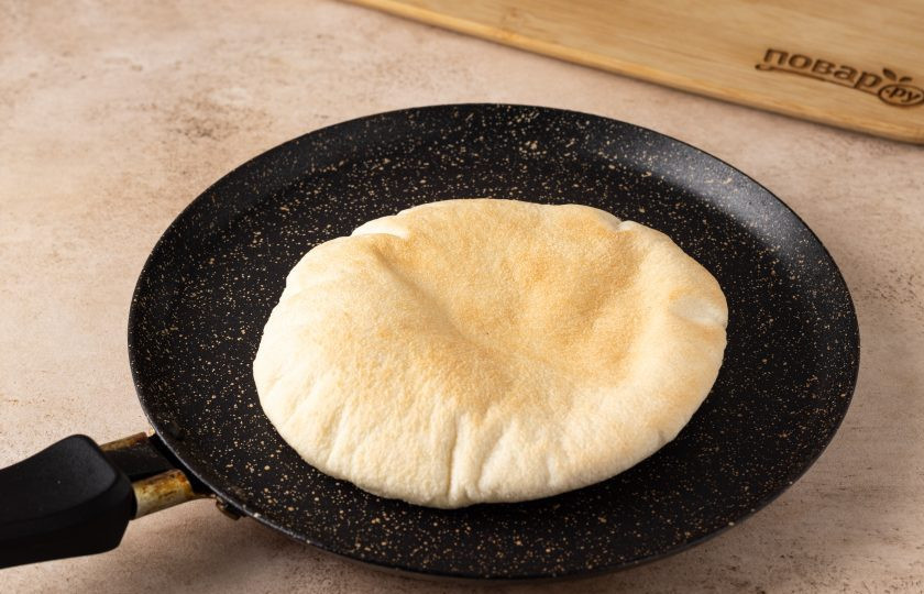 1. Этап. Фалафель в пите с салатом и помидором: Питу подогрейте в сухой сковороде, чтобы она стала мягче. Затем разрежьте пополам.