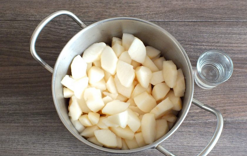 1. Этап. Груши со сгущенным молоком на зиму: Удалите семечки и нарежьте грушу на кусочки в пределах 3-4 см. Переложите в кастрюлю с толстым дном. Добавьте воду. Поставьте на умеренный огонь. Как только закипит, огонь убавьте до минимума и варите 30 минут.