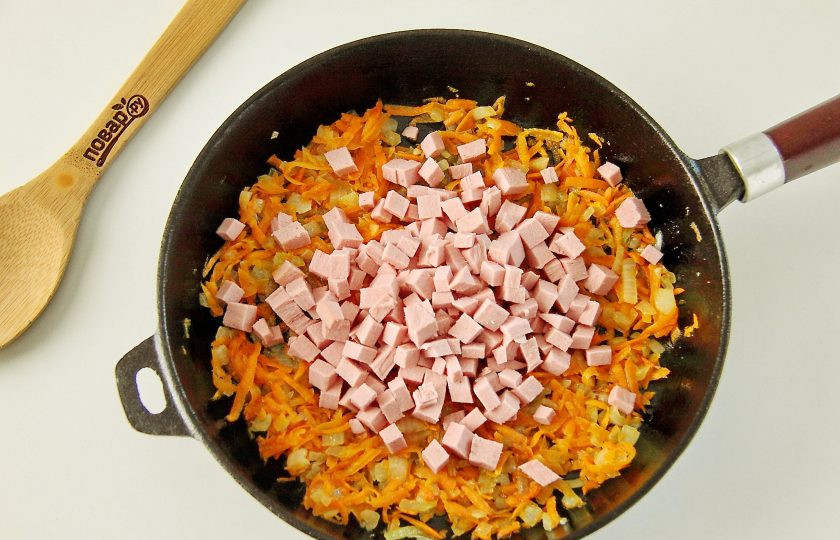 1. Этап. Пицца с морковью: Обжарьте овощи на сковороде до мягкости. Добавьте нарезанную кубиками колбасу.