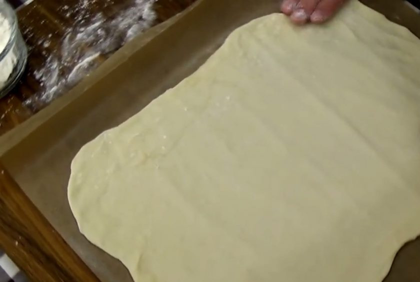 1. Этап. Лаваш-крекер: 3. Разделите тесто на две части и раскатайте в тонкий пласт. При помощи скалки перенесите пласт на бумагу для выпечки и дайте постоять при комнатной температуре 10 минут.