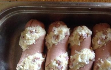 1. Этап. Фаршированные сардельки: В разрезы на сардельках плотно уложить начинку из картошки, колбасы и сыра. Выкладываем в слегка смазанную маслом форму. Можно дополнительно сверху посыпать тертым сыром