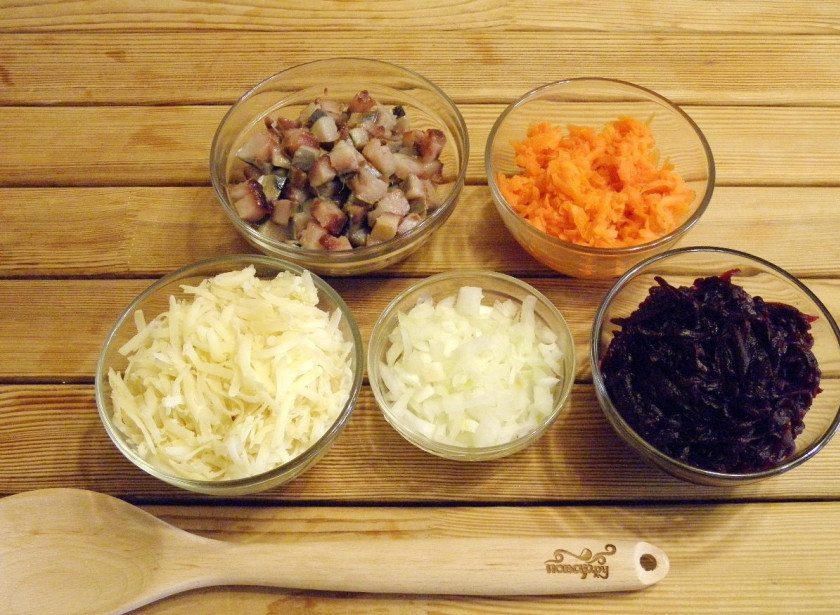1. Этап. Селедка под шубой без яиц: Порежьте рыбное филе кубиками не большого размера. Овощи натрите на крупной терке. Лук порежьте мелкими кубиками. При желании можно замаривать в уксусе с водой и сахаром.