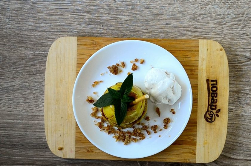 1. Этап. Яблочный крамбл с мороженым: Соберите десерт. Выкладывайте на плоскую тарелку кружочки яблока, присыпая каждый сладкой крошкой из печенья. В отверстие вставьте сладкую палочку и воткните небольшую веточку мяты. Подавайте яблочный крамбл с кружочком ванильного мороженого. Кушайте с удовольствием!