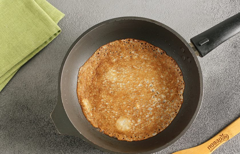 1. Этап. Блины на праздничный стол: Разогрейте сковороду и смажьте ее маслом (достаточно сделать это один раз перед первым блинчиком). Налейте тесто половником, распределяя его по всей сковороде. Пеките блинчики с двух сторон до золотистого цвета. Чтобы края блинчиков в процессе не подсохли, складывайте их стопочкой и накрывайте полотенцем.