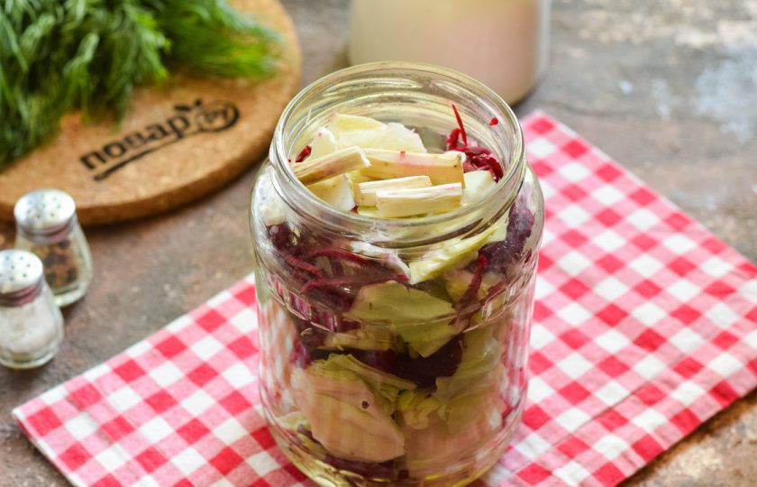 1. Этап. Капуста со свеклой и хреном на зиму: Банку для заготовки вымойте с содой, ополосните и стерилизуйте над паром. У меня используется банка объемом 1 литр. Крышку проварите в кипятке 10 минут. Наполните банку капустой и свеклой, чередуя слои. Поверх выложите очищенный хрен.