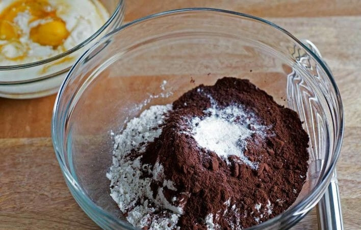 1. Этап. Кексы Двойной шоколад: 1. В миске смешайте муку, 1/2 стакана какао-порошка, разрыхлитель, пищевую соду, соль и сахар, в другой миске смешайте яйца, кефир, рапсовое масло и ваниль. Налейте кефирную смесь к сухим ингредиентам и тщательно перемешайте.