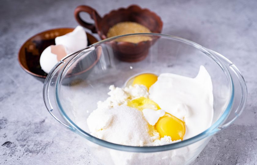 1. Этап. Творожная запеканка с кукурузной крупой: В просторную миску выложите весь творог, добавьте сметану, сахар, соль, вбейте яйца.