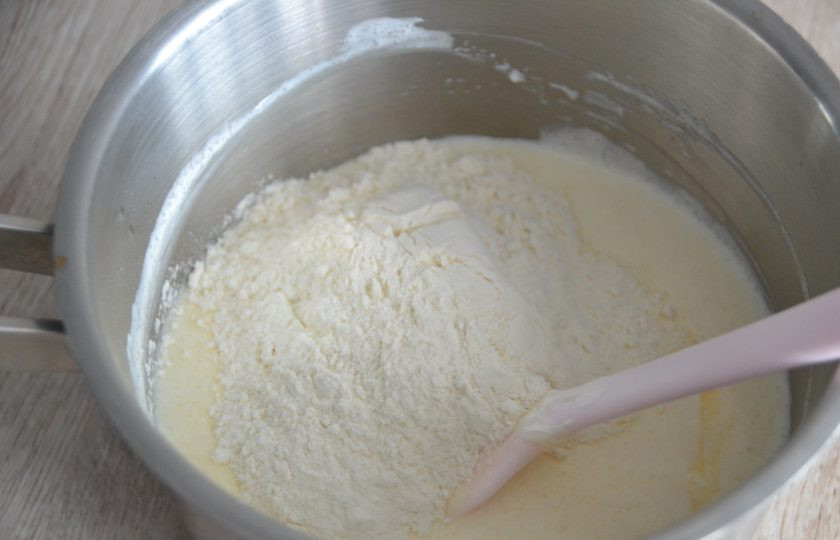 1. Этап. Эклеры со сметанным кремом: Добавьте в сотейник 3 ст. ложки муки с горкой, ванильный сахар, еще раз перемешайте.