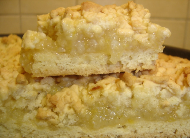 1. Этап. Тертый пирог с лимоном: 7. Достаньте из морозилки оставшийся кусочек теста. Натрите его на терке над пирогом. Разогрейте духовку до 220 С. Выпекайте пирог на протяжении 25-30 минут. Затем достаньте его из духовки и нарежьте порционными кусочками. Дайте ему остыть и посыпьте сахарной пудрой.