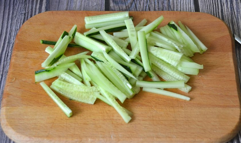 1. Этап. Салат с копченым сыром Косичка: Нарежьте тонкой соломкой огурец.