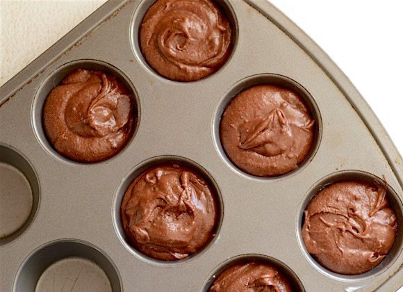1. Этап. Простые шоколадные кексы: 4. Оставшейся ложкой сливочного масла смажьте формы для запекания, выложите в них тесто.