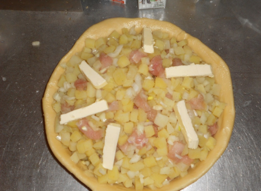 1. Этап. Пирог Курник: А, чуть не забыла, у меня форма старая, добрая чугунная сковорода, я ее просто смазала подсолнечным маслом. Можно чуть присыпать мукой. Итак, после того, как первый слой у нас в форме, катаем второй. Катаем его один в один с размером формы, чтобы не было не красивых складок. Он получиться тоже не тонкий и это нормально. Теперь выкладываем аккуратно и равномерно начинку, не пугайтесь, если вам покажется ее много, ложите прям горкой, Так надо. (именно поэтому мы заранее отварили картофель, чтобы не переживать, что пирог не пропечется!) сверху режем немного сливочного масла.