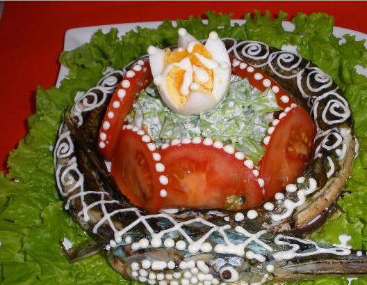 1. Этап. Украшение фаршированной рыбы: 4. Готовую рыбу выкладываем кольцом, по центру горкой выкладываем порцию салата. Вокруг салата - колечки помидоров, сверху размещаем яйцо. Дальше - украсим майонезом на свой вкус. Все готово!