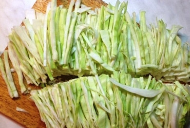 1. Этап. Свежая капуста жареная: Нарезаем капусту тонкой соломкой, а потом эту длинную соломку режем пополам. Слегка помнем капусту, так она будет нежнее и быстрее приготовится.