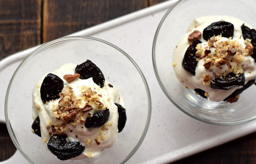 1. Этап. Чернослив с грецким орехом в сливках: Орехи, которые оставляли, нарежьте ножом на кусочки разных размеров. Орехами присыпьте верхний слой десерта.