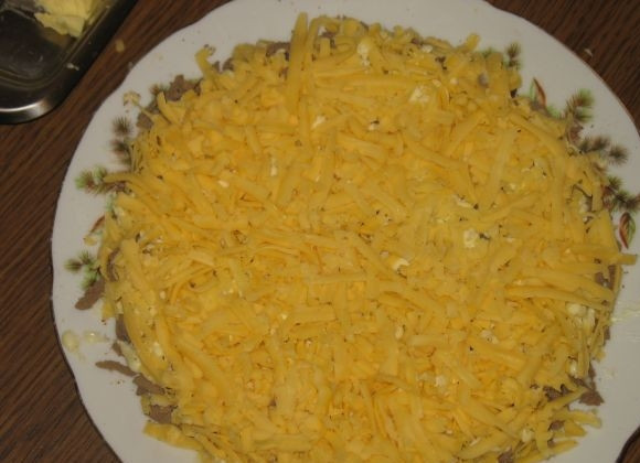 1. Этап. Новогодний печеночный торт: Затем выкладываем слой сыра и смазываем майонезом.