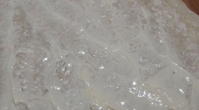 1. Этап. Рулет из лаваша с грудкой: Большой лаваш разделите на 6-8 ровных частей. Каждую часть смажьте плавленым сыром с одной стороны.