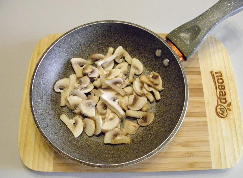 1. Этап. Омлет с ветчиной, грибами и сыром: 2. Шампиньоны порежьте тонкими пластинками и обжарьте на растительном масле со щепоткой соли до готовности. Периодически помешивайте, чтобы не пригорели, огонь не большой. Готовые грибы переложите в тарелочку и вымойте сковороду, вытрите насухо.