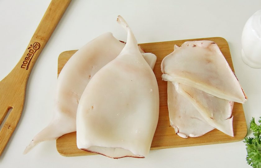 1. Этап. Фаршированные кальмары Мышки: Снимите у кальмаров пленку, удалите внутренности и хорду, после чего промойте их под проточной водой. Срежьте аккуратно плавники.