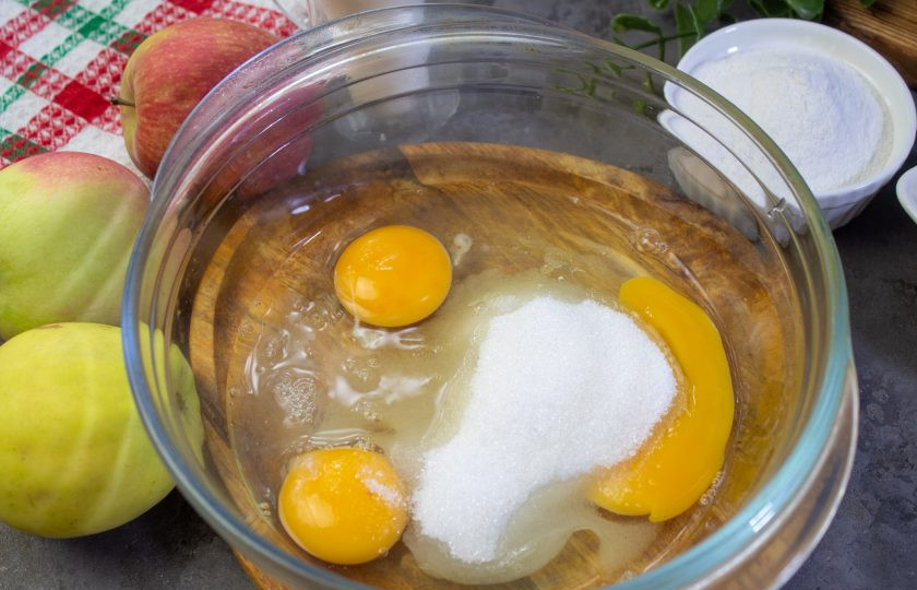 1. Этап. Яблочный пирог сестёр Симили: Яйца вбейте в миску, добавьте соль, сахар и ванилин. Перемешайте венчиком.
