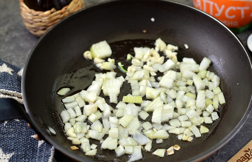 1. Этап. Бюргерская тушеная капуста: Нарежьте лук мелким кубиком, порубите чеснок, переложите их в разогретое растительное масло на сковороде. Обжарьте минуты 2 на умеренном огне.