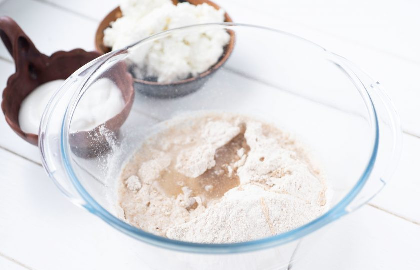 1. Этап. Диетические вареники: В просторную миску высыпите всю цельнозерновую муку, добавьте воду и растительное масло.