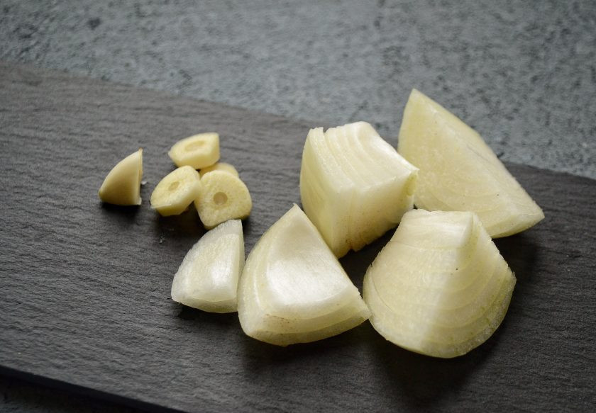 1. Этап. Котлеты из чечевицы и риса: Нарежьте чеснок и лук крупными ломтиками. Измельчите их в мясорубке или блендере вместе с чечевицей.