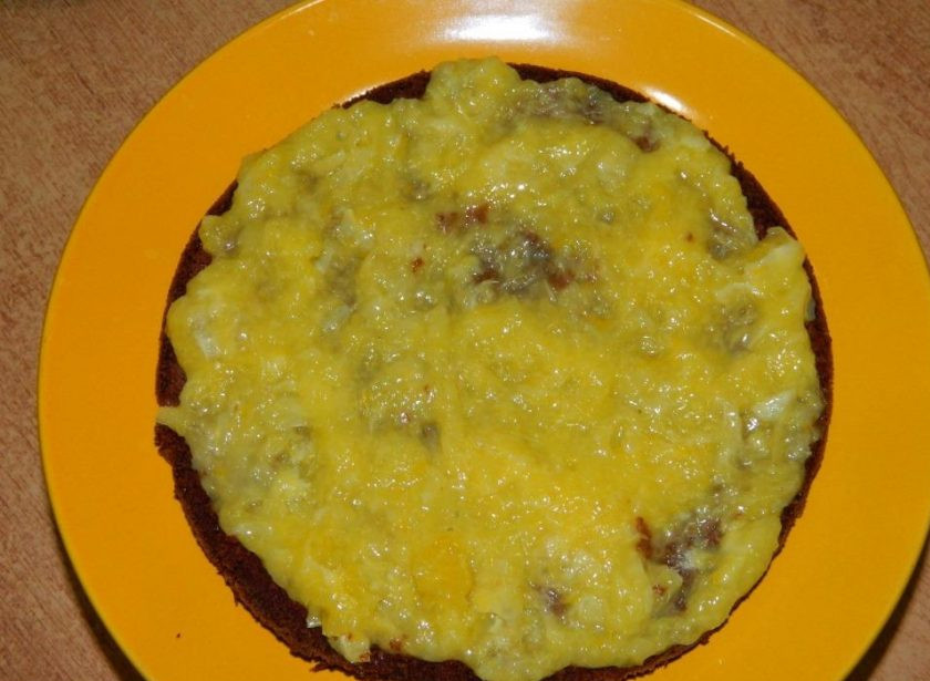 1. Этап. Креативный торт для мужчины: На один слой бисквита выложите немного апельсиновой начинки.