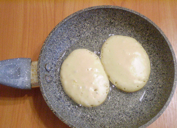 1. Этап. Оладьи на кефире с яйцами: Разогрейте масло в сковороде. Столовой ложки выливайте тесто, формируя овалы. Жарьте.