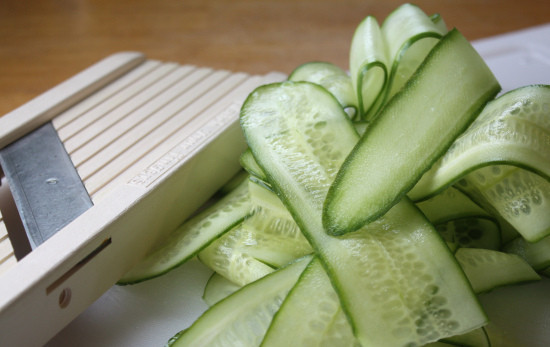 1. Этап. Салат с семгой и огурцом: 1. Огурцы или длинный огурец промойте, срежьте кончики. Нарежьте тонкими пластинками при помощи овощечистки. Помидоры промойте, вырежьте плодоножку и нарежьте четвертями. Синий лук почистите и нарежьте тоненькими полукольцами. Укроп промойте, просушите и измельчите.