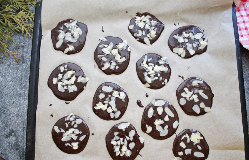 1. Этап. Шоколадные чипсы с миндалем: Противень застелите пергаментом и выложите по одной столовой ложке теста на расстоянии. Посыпьте верх миндальными чипсами и поставьте в горячую духовку в течение 7 минут при температуре 170 градусов.