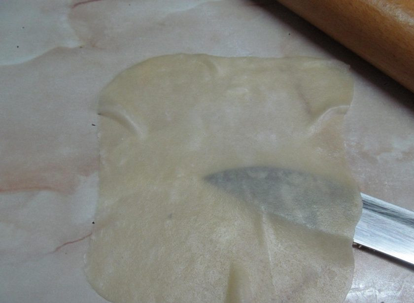 1. Этап. Пирожки из заварного теста с тунцом: Каждый кусочек раскатайте в очень тонкую лепешку, чтобы тесто было прозрачным.