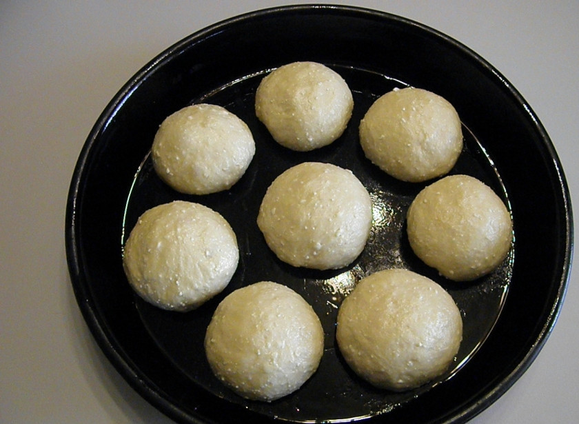 1. Этап. Творожные булочки в сметанной заливке: Разделите тесто на равные части. Количество частей по желанию, я разделила на 8 частей, булочки получились очень большие. Сформируйте круглые красивые шарики. Выложите на смазанный рафинированным маслом лист. Оставьте подходить на 20 минут. После смажьте желтком и поставьте в горячую духовку выпекаться. Температура 180 градусов, время 30 минут.