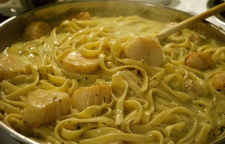 1. Этап. Паста с гребешками в сливочном соусе: Теперь мы выкладываем на сковороду нарезанный кубиками лук и жарим его 3-5 минут, затем добавляем измельченный чеснок. После того как появится приятный чесночный аромат, вливаем на сковороду сливки, добавляем песто, оставшуюся ложку смеси специй и соль по вкусу. Перемешиваем все и готовим соус 2-3 минуты, за это время он должен вдвое уменьшиться в объеме. Далее выкладываем в соус гребешки и сваренную пасту, можно добавить немного водички (в которой паста варилась).