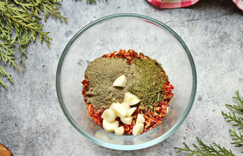 1. Этап. Аджика из сухого острого перца: Чеснок почистите и разрежьте на куски, добавьте уцхо-сунели и сухую кинзу. Все перемешайте и пропустите смесь через мясорубку с мелкой решеткой. Получившуюся смесь прокрутите через мясорубку еще раз.